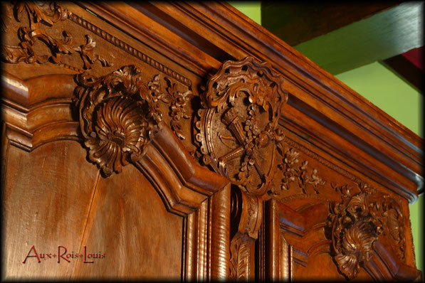 On the upper crosspiece, beneath the cornice, an inset contains a stunning coat of arms representing the family who commissioned this unique piece.