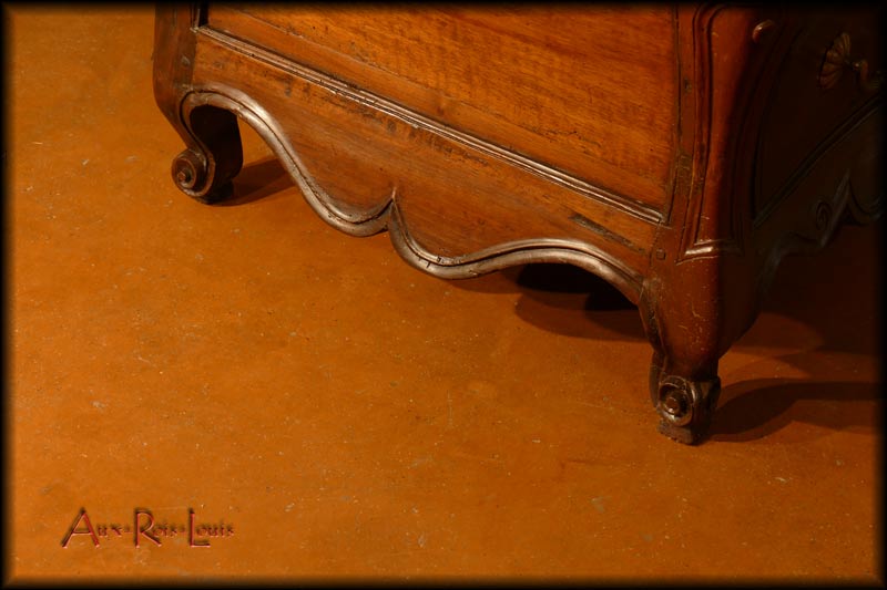 This piece of furniture stands on four carved scroll feet beneath a moulded crosspiece.