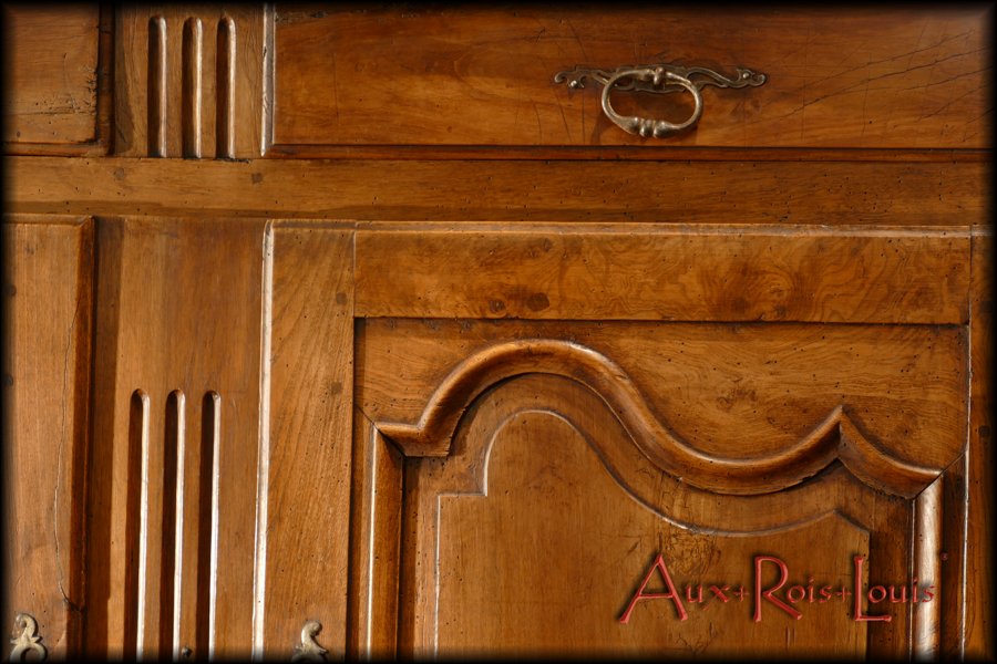 The scalloped moldings projecting on the doors as well as the grooves on the central frame ennoble this country sideboard.