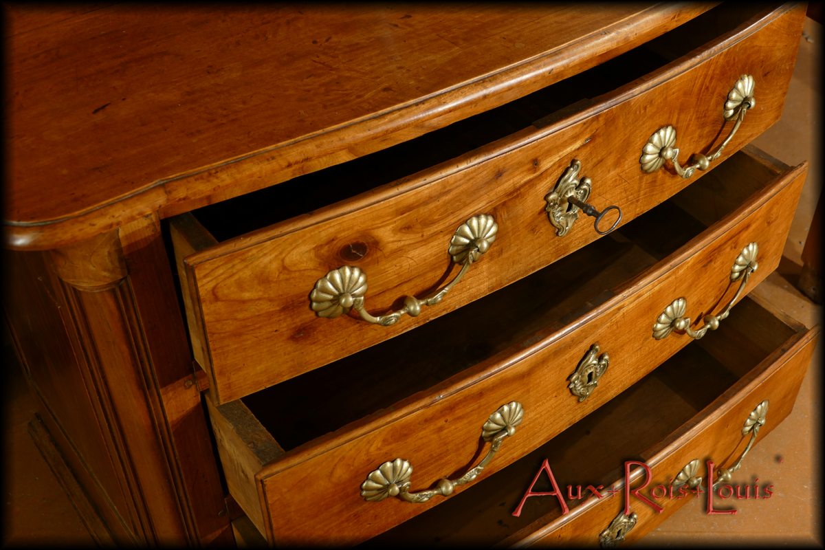 Les tiroirs sont pourvus de belles poignées en bronze, particulièrement mises en valeur par une essence de bois claire.