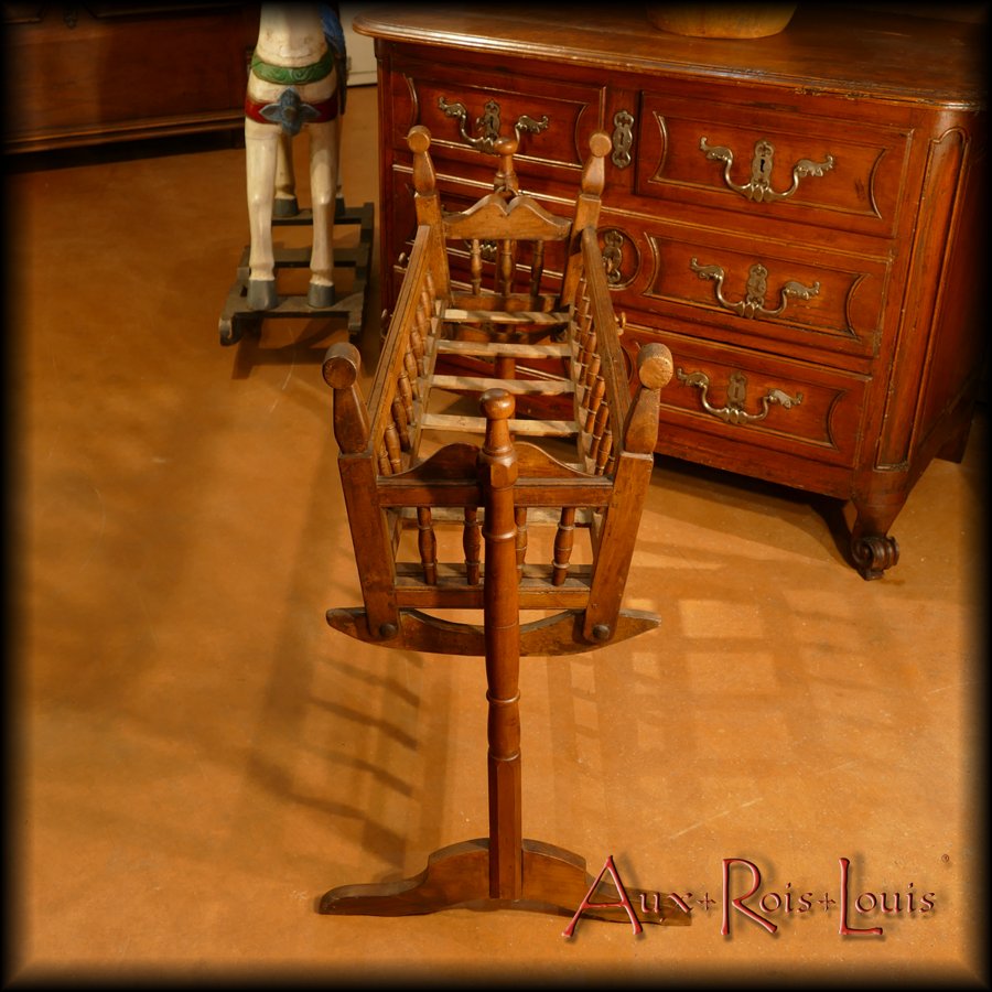 This cherry wood rocking cradle comes from the 1850s, steeped in the Louis-Philippe style which is expressed by a simplification of the structure and a softening of the forms.