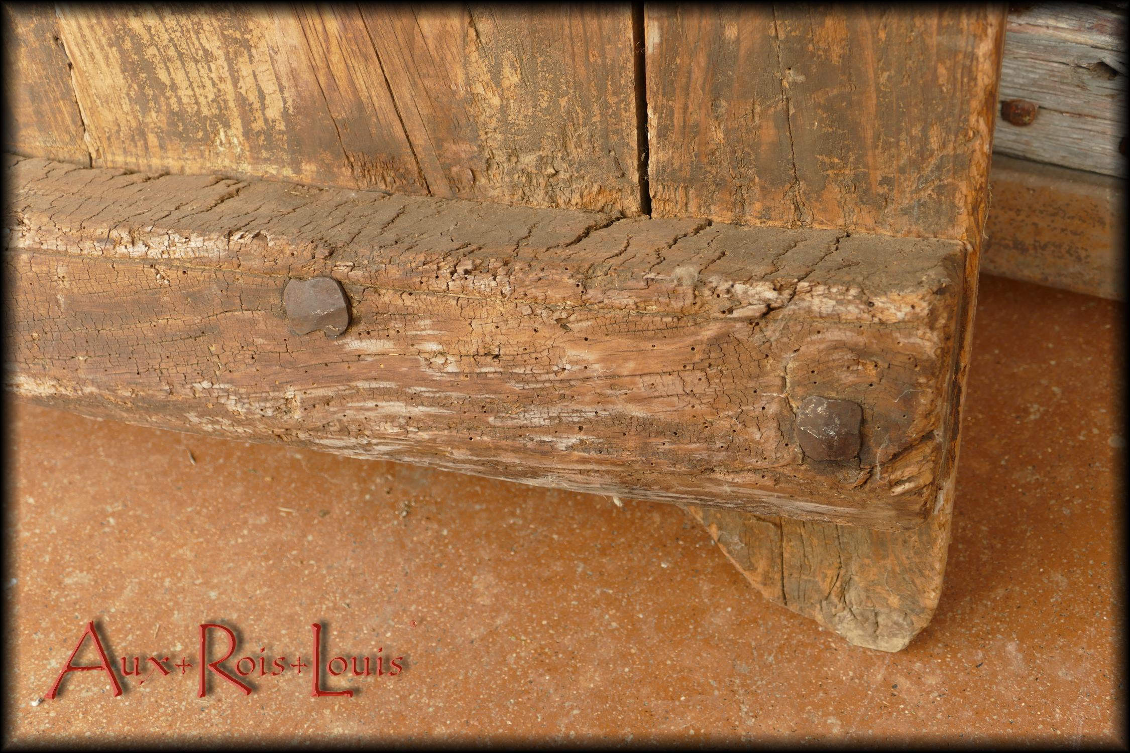Détail de la traverse du bas avec de plus près deux têtes de clous forgés tels qu'on les martelait manuellement au XVIIIᵉ siècle en Aveyron.