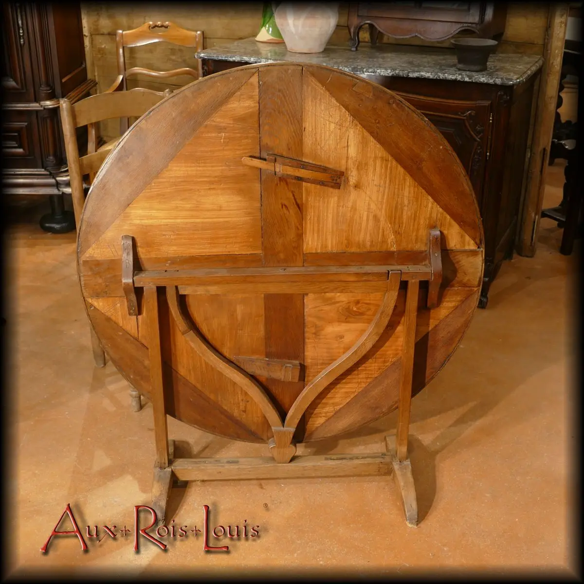 In this raised position, the top reveals the pivoting lyre and the wooden spring from below to fix it to ensure the stability of the top in the table position.