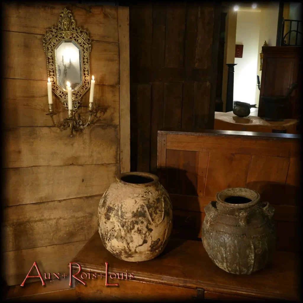 Two walnut oil jugs, fuel used in the 18th century for lighting. The mélard on the left is in raw white clay on which concretions come from the interior. The mélard on the left benefited from a water-green glaze which made it waterproof. Its two handles allow it to be hung on a rope to be able to lean it and thus facilitate the flow of oil.