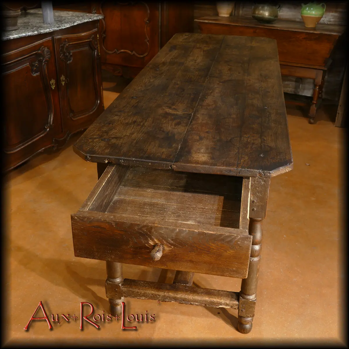 Le tiroir ouvert met en valeur l’épaisseur des planches de chêne choisies au XVIIᵉ siècle pour fabriquer cette grande table Louis XIII.