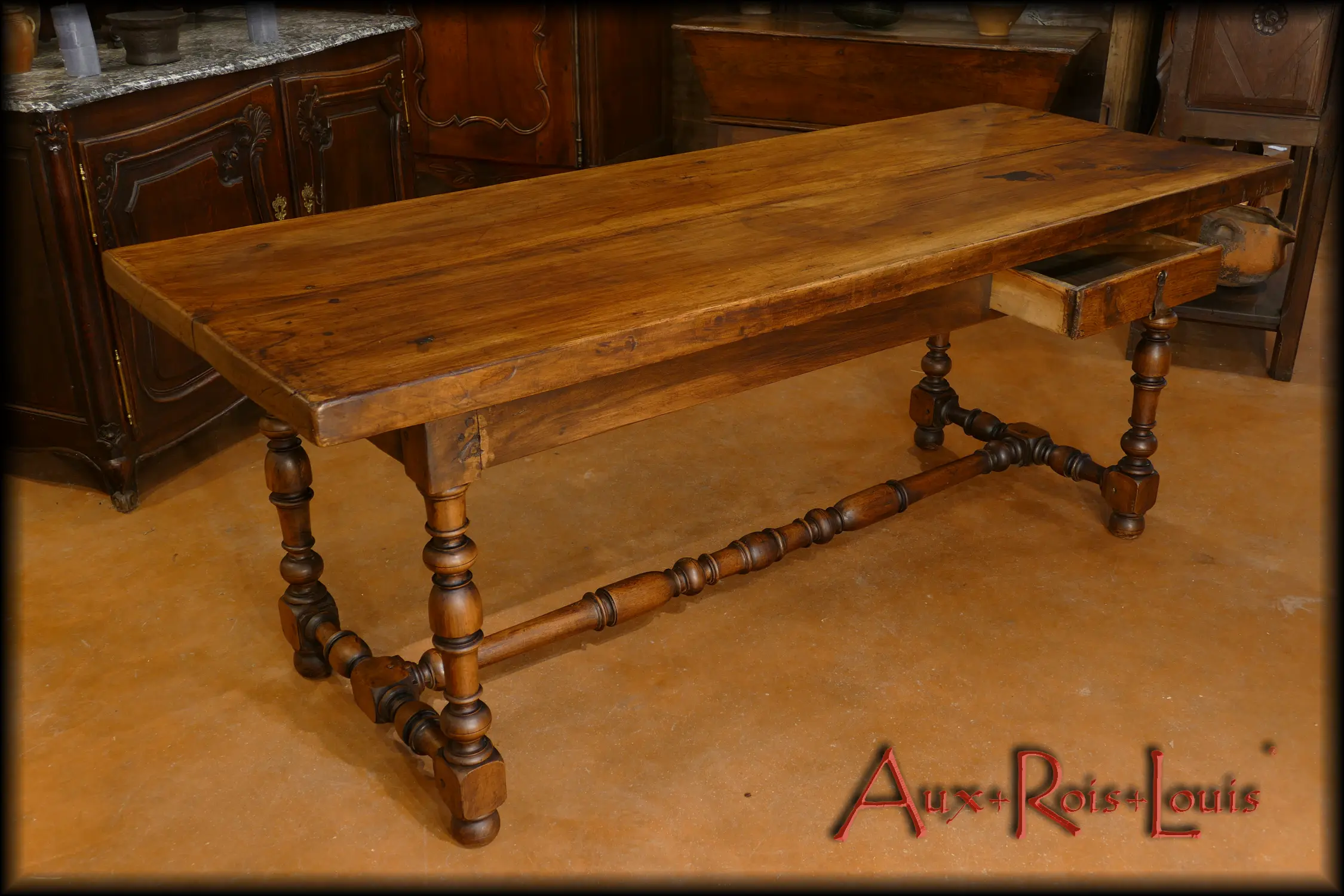 Cette table en chêne de style Louis XIII dispose d’un petit tiroir latéral pour les couverts.