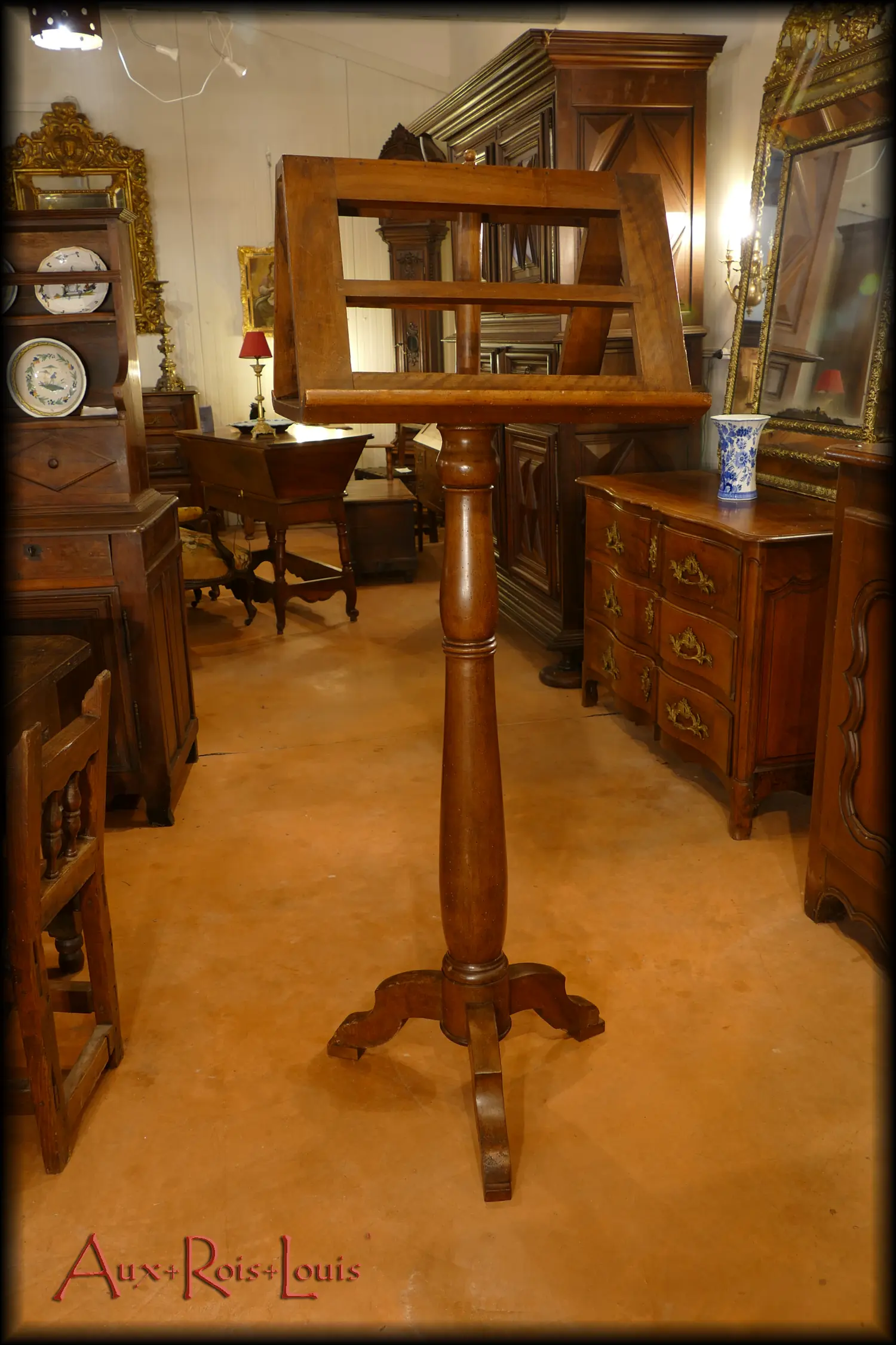 Here is an antique musician's lectern made of walnut from the 18th century in the Southwest region of France. It features a double openwork music stand resting on a solid wooden tablet, which contributes to its stability. Its base consists of three legs arranged in the manner of tree roots, ensuring its balance.