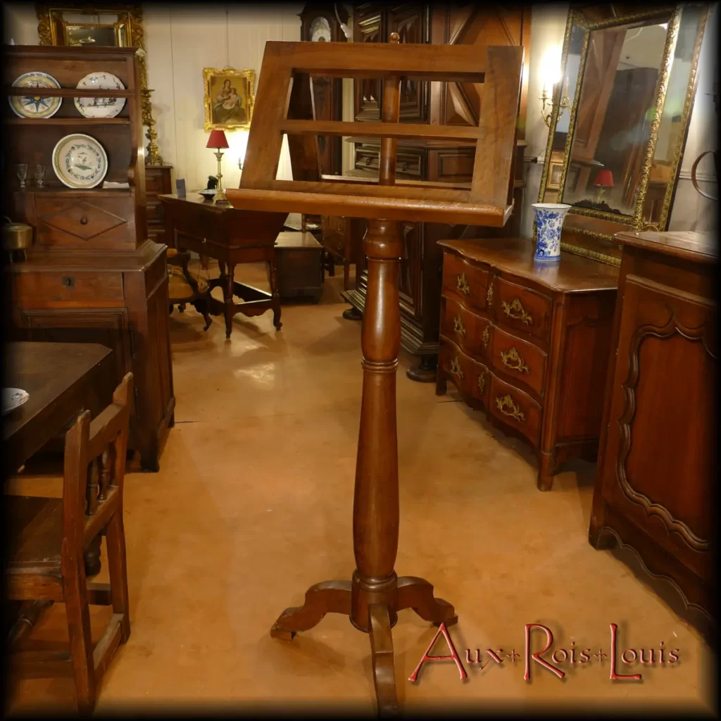 Here is an antique musician's lectern made of walnut from the 18th century in the Southwest region of France. It features a double openwork music stand resting on a solid wooden tablet, which contributes to its stability. Its base consists of three legs arranged in the manner of tree roots, ensuring its balance.