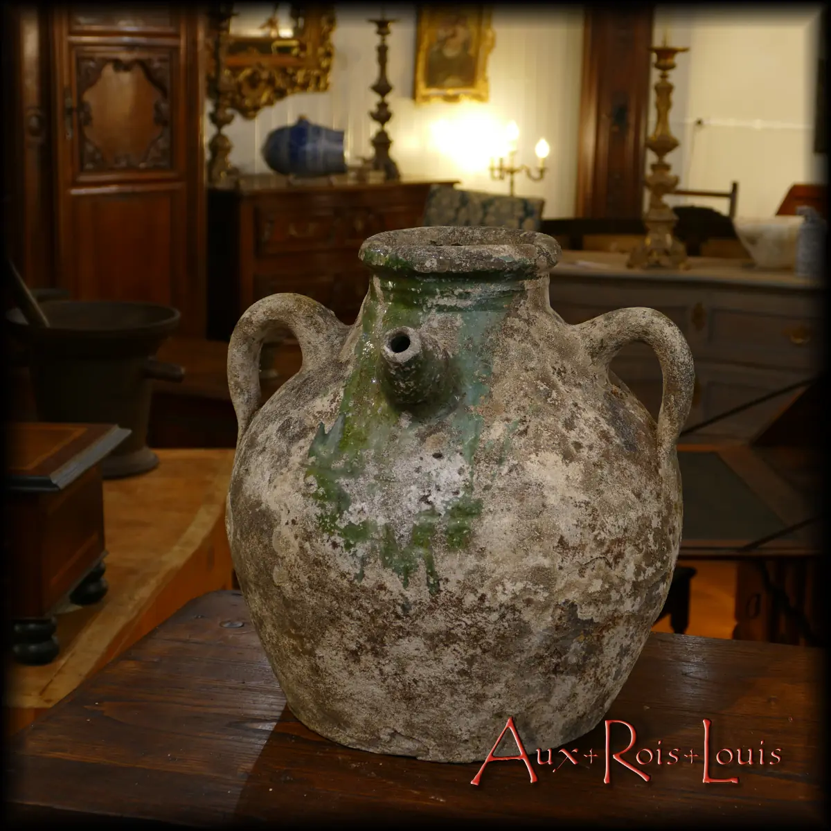 This oil jar, crafted in Saintonge during the 19th century, has acquired a patina over time, now displaying a stone-toned patina, mixed with a verdant moss at the historical location of its protective “bavette” against thick walnut oil spills, which was used for domestic and municipal lighting back then.