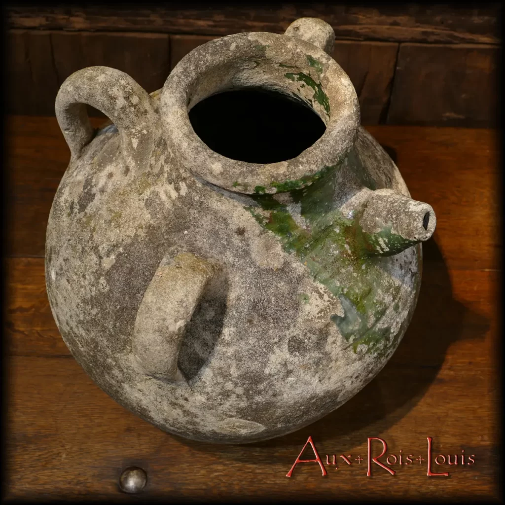 Statufied and adorned with an emerald scarf, its gentle belly fears no ravages of time. On the contrary, it enhances it, turning this Charente pottery into a star jar, or dare I say, an authentic oil of the upscale districts.
