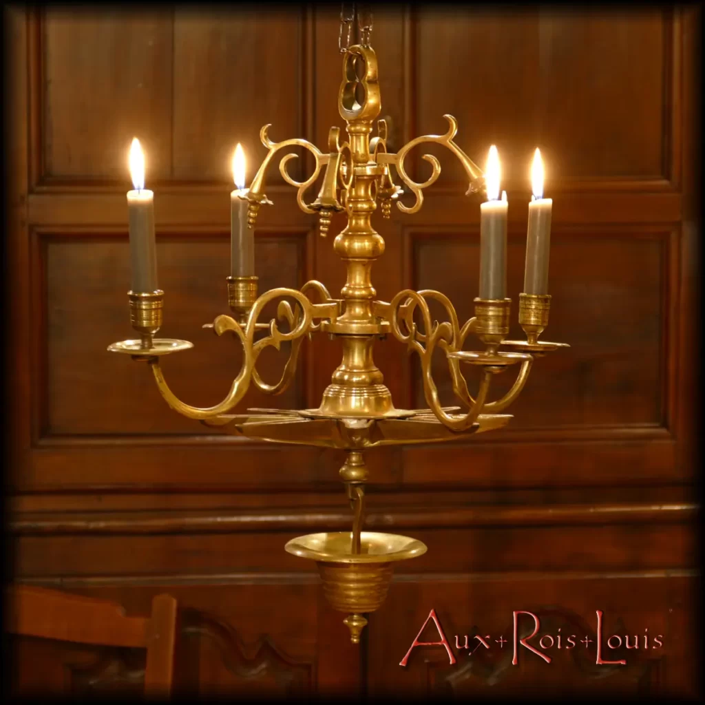 What characterizes this bronze chandelier from the 17th century is that it has never been converted to electricity. Everything here is original, and only the candles are adapted to its candle holders. Additionally, small vessels are intended to receive walnut oil and wicks to complete the decidedly intimate lighting setup.
