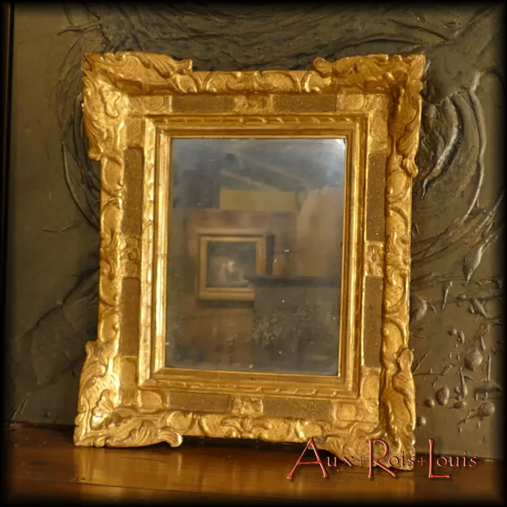 This little Louis XIV gilded mirror illustrates the savoir-faire of 18th century miroitiers, guillocheurs, stuqueur and gold leaf gilder. It will bring happiness in a secret boudoir where it will have the place of honor.