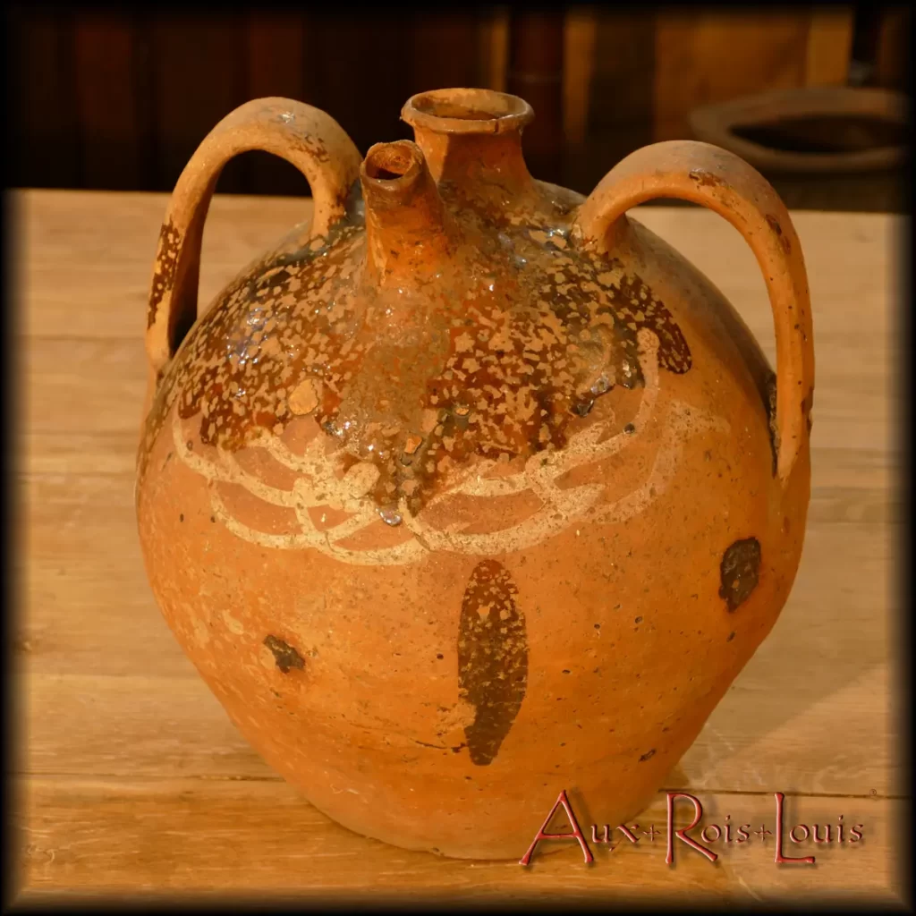 Cette cruche à eau en terre cuite vernissée provient d’un atelier de campagne situé à Brioude, en Haute-Loire. Ce type d’atelier de poterie auvergnat ne fonctionnait qu’en hiver, lorsque les paysans étaient libérés des travaux des champs. L’argile est rouge car naturellement chargée en oxyde de fer. Cette argile brute était chamottée, c’est-à-dire chargée en sable de rivière et en poudre d’argile cuite puis concassée.