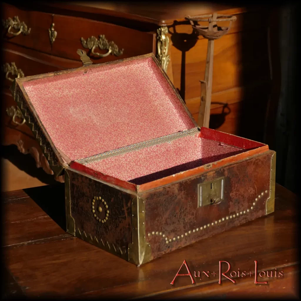 This 18th-century coach chest is clad in leather on the outside and bordered with studded brass. The interior is lined with hand-painted wallpaper, forming speckled patterns. Originally, this type of luggage was the work of the guild of trunk makers, a separate trade from the saddle makers, emerging during the 14th century.